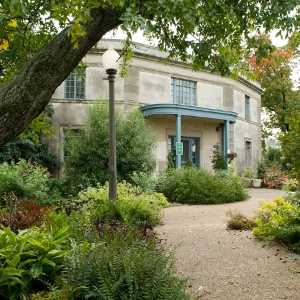 Building at the end of a tree lined path.