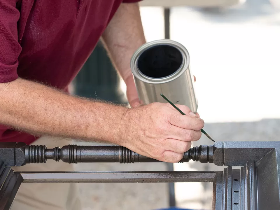 Touching up protective lacquer on the bronze framing of a lantern before it was reinstalled on its stone pier.
