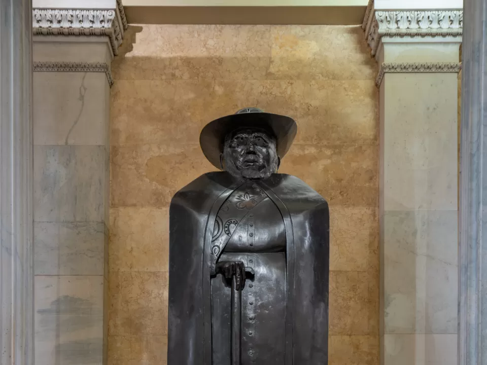 Bronze statue of a person standing.