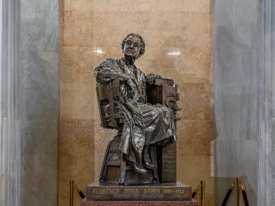 Bronze statue of a person sitting.