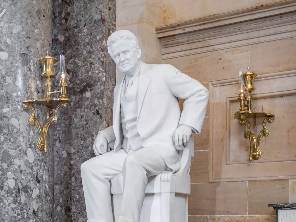 Marble statue of a person sitting.