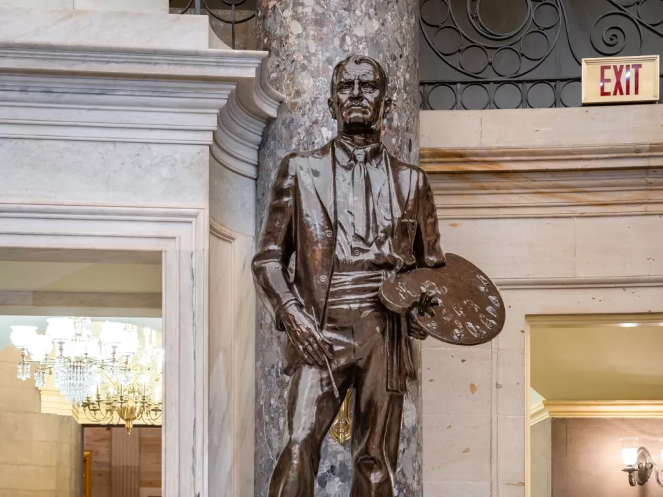 Bronze statue of a person standing.