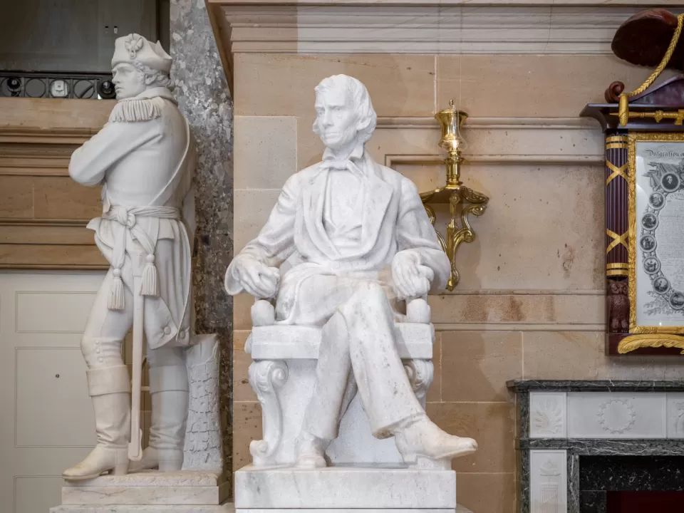 Marble statue of a person sitting.