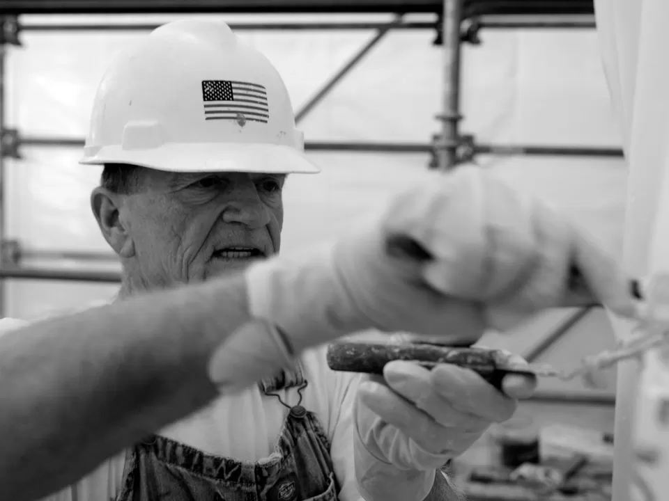 Person wearing a hardhat with a United States flag on it.