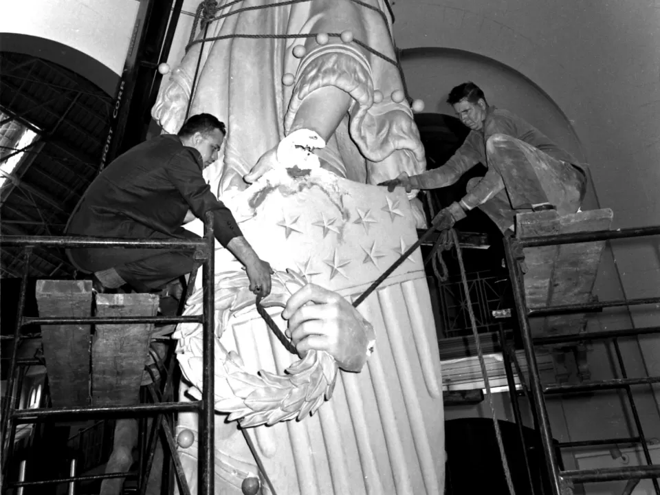 Two people working on a statue.