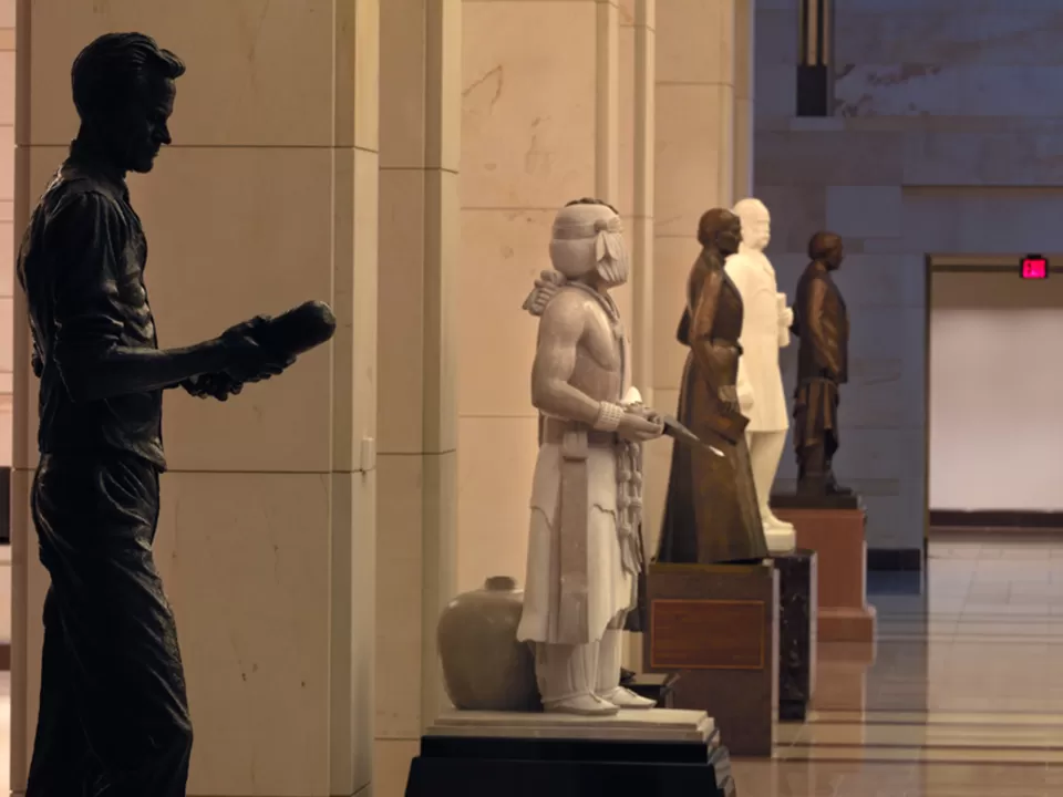 Statues lined up against columns.