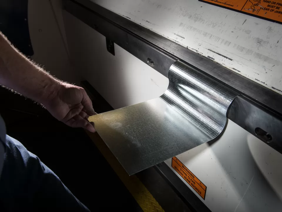 Mark Focht, Capitol Building Sheet Metal Shop, shows a section of gutter he created with the auto brake and demonstrates its use.