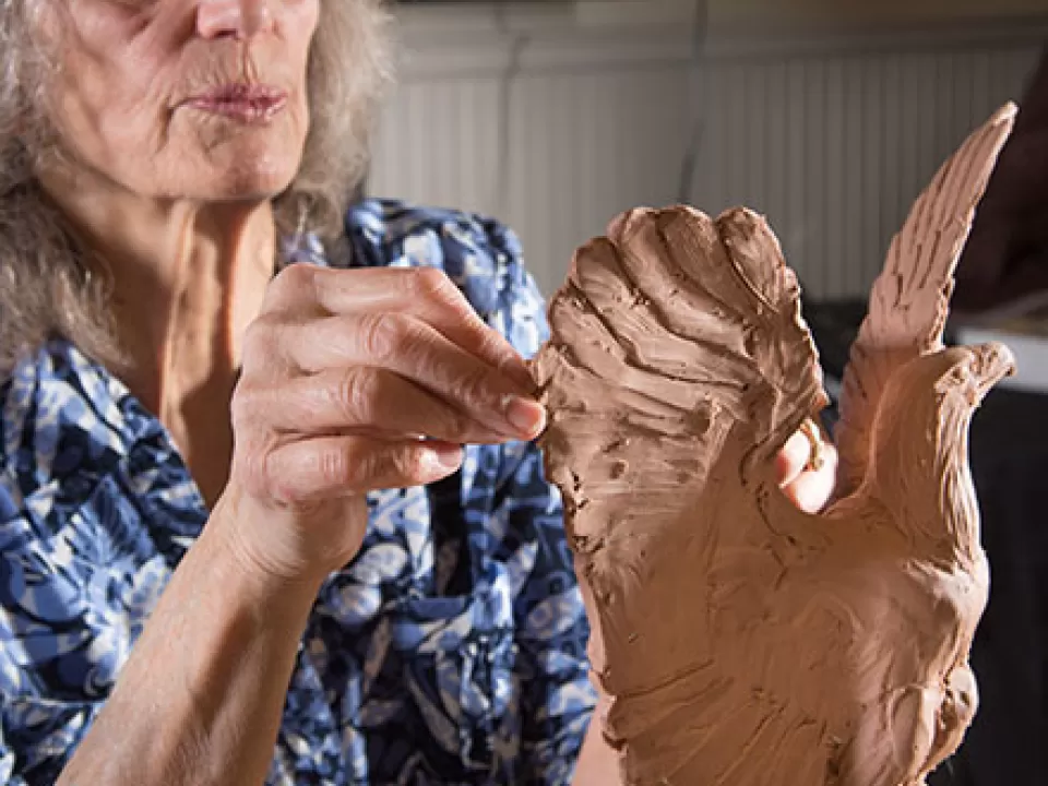 An artist creates a clay model of an eagle to go atop a light post at the Grant Memorial.