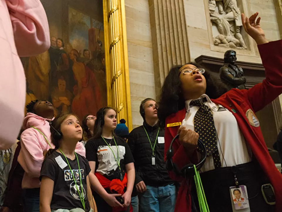 A visitor guide shows a tour group through the U.S. Capitol Rotunda.
