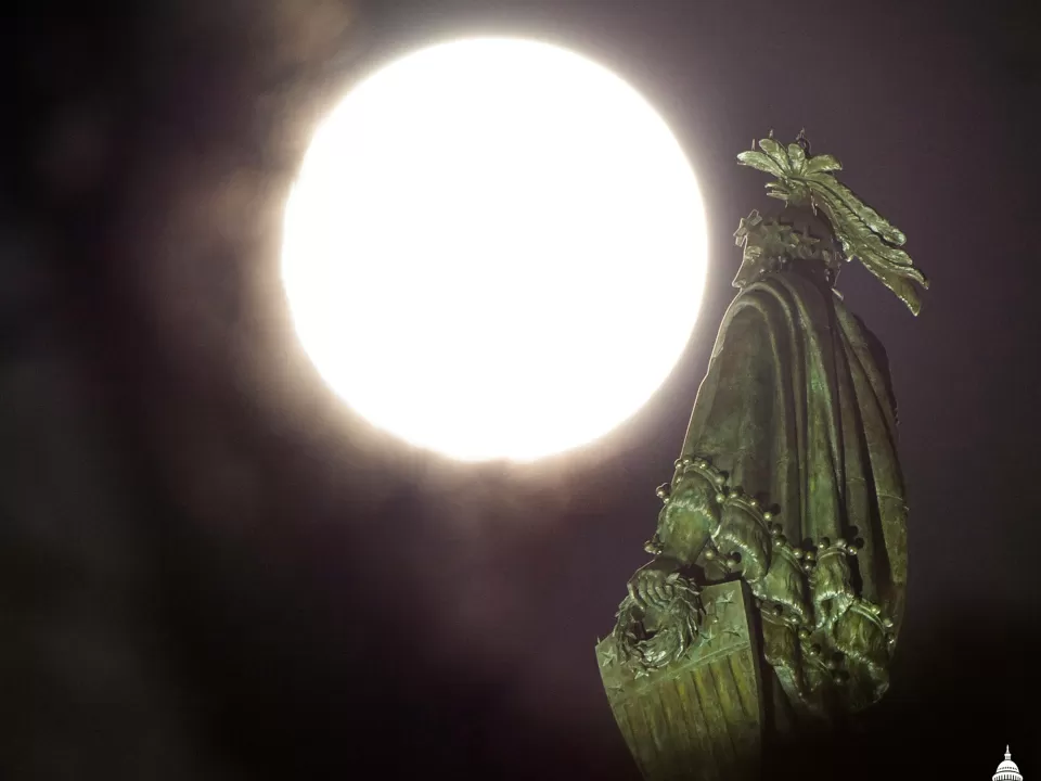The moon and a statue of a person.