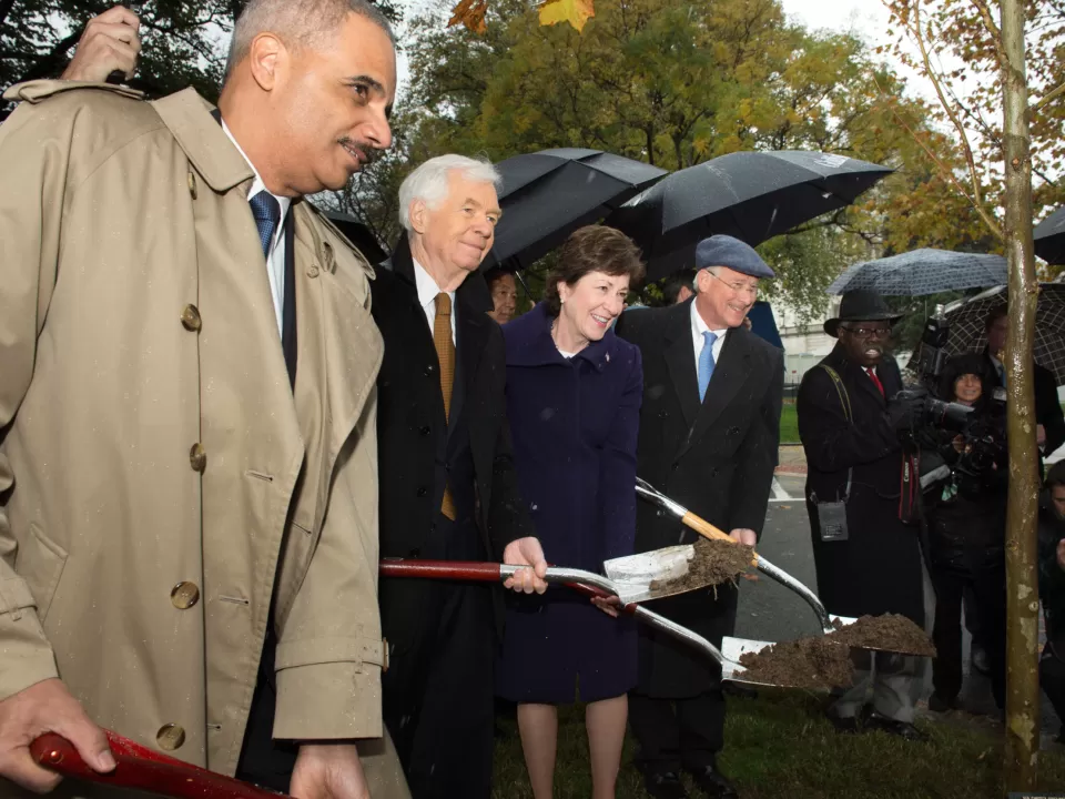 People standing holding shovels.