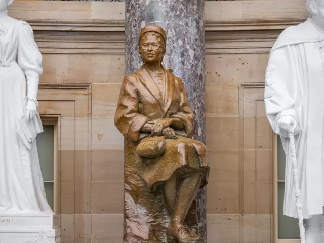 Bronze statue of a person sitting.