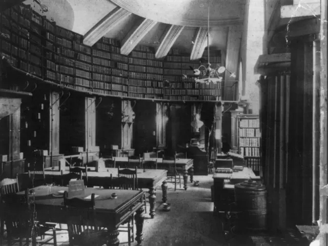 Desks with chairs and shelves with books.