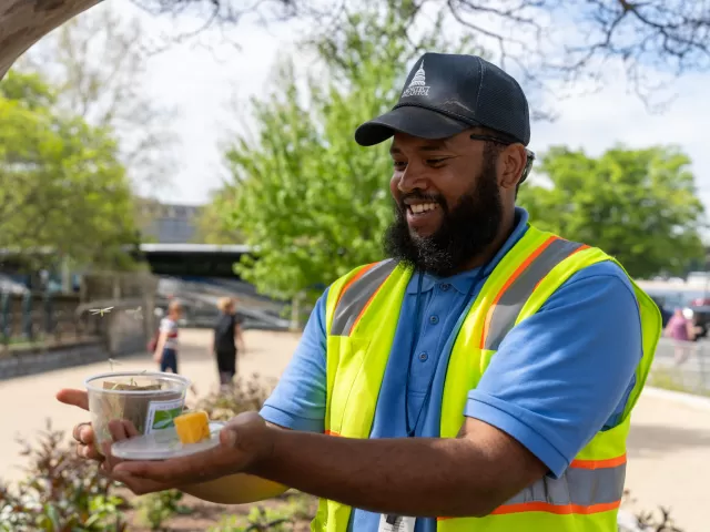 Person holding a container with the lid off.