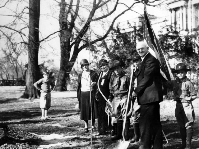 People standing holding shovels.