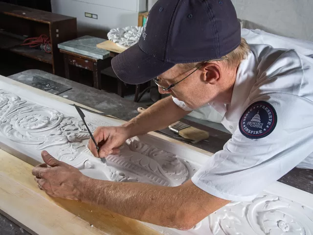 Robert Gannon smoothes out imperfections in a plaster cast.