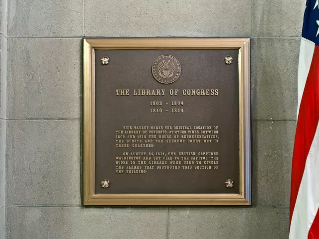 Plaque with text and a portion of the U.S.A. flag.