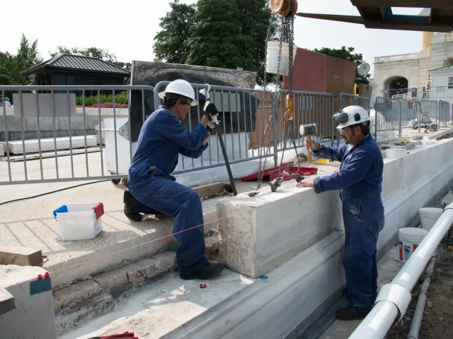 Two people working with stone.