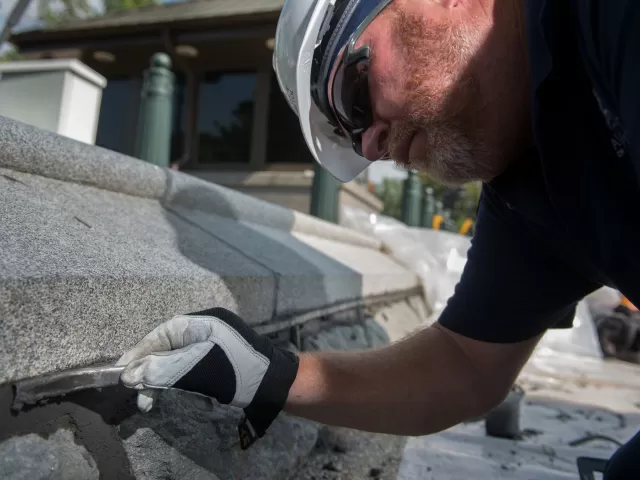 Russell Jones of the AOC Construction Division demonstrates a cool tool for applying grout to the Olmsted wall.