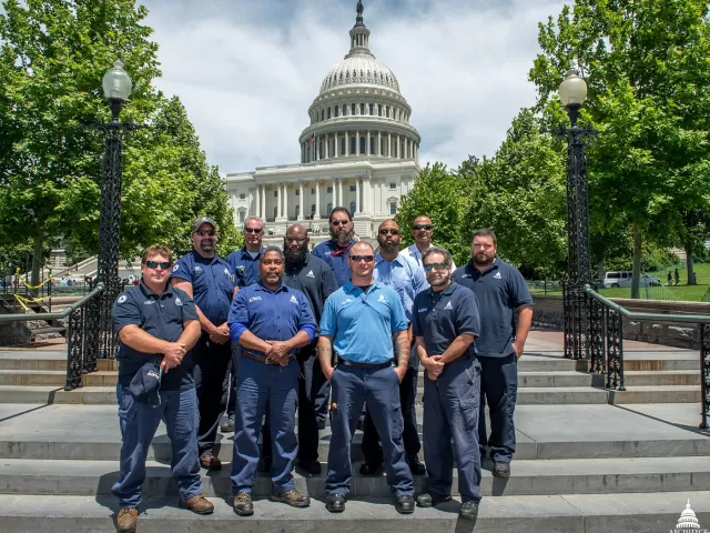 Group photo of the Architect of the Capitol high-voltage electricians on the West Front of the U.S. Capitol.