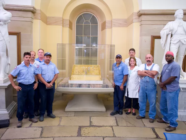 Group of people standing with statues.