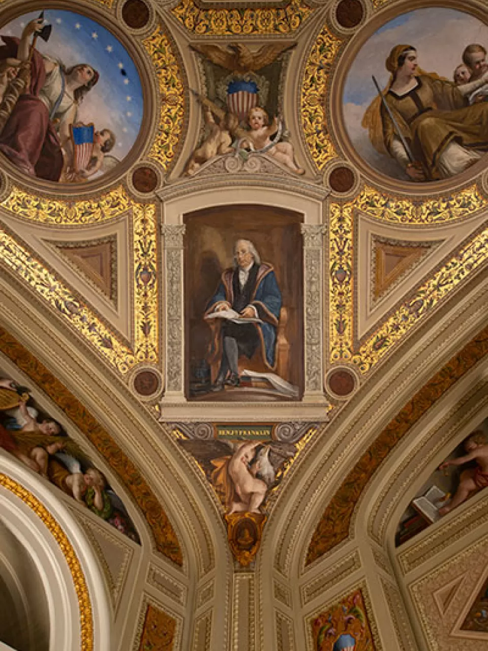 Benjamin Franklin reading a sheet inscribed "Buon Uomo Ricardo" ("Poor Richard" in Italian), referring to his almanac, and surrounded by books, newspapers and a printing press, for History. 