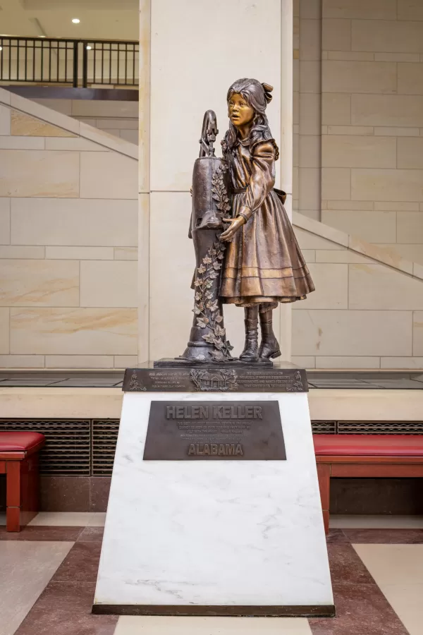 Bronze statue of child standing.