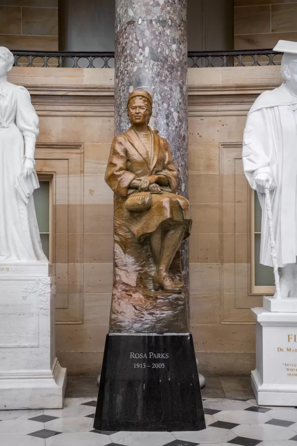 Bronze statue of a person sitting.