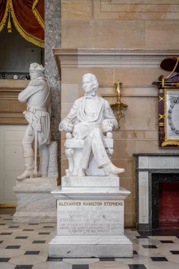 Marble statue of a person sitting.