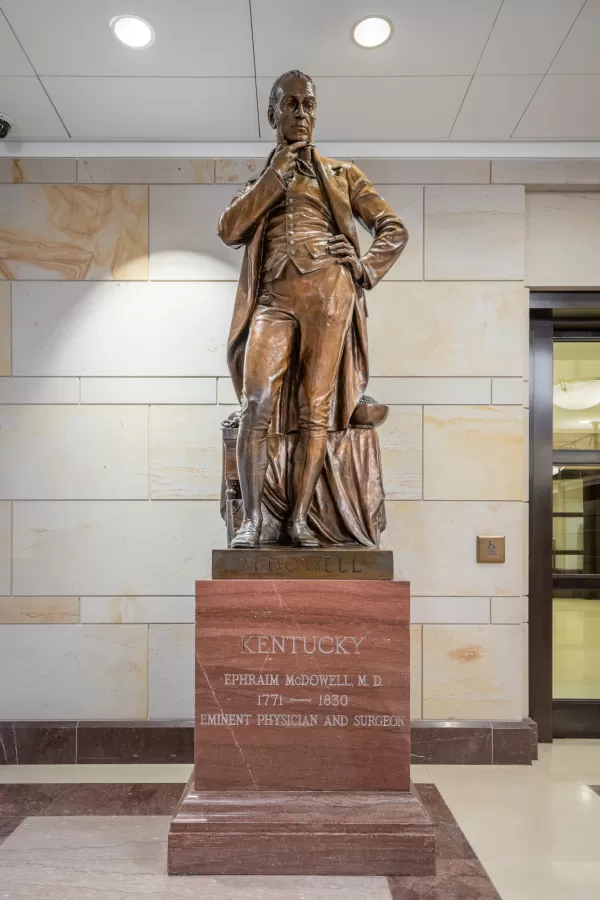 Bronze statue of a person standing.